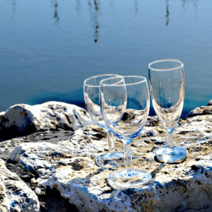 Verres ridak à eau, vin et flute à champagne au bord d'un lac pendant un mariage